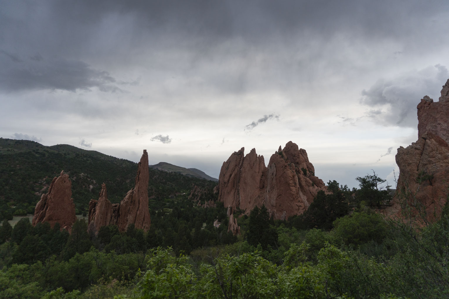 Red rock formations stick out of the green vegetation